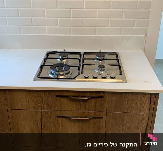 כיריים גז עם ארבעה מבערים על משטח שיש